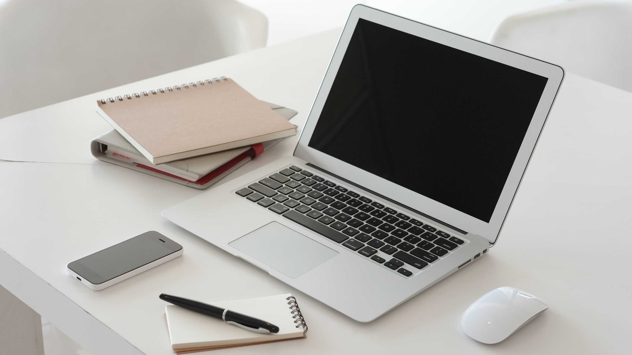 a laptop an d a notepad on a table